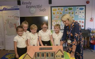 Holbrook Primary School headteacher Vicki Cottrell and pupils take a close look at the specially-made cake identical to the new Coronation Building when it opened last September.