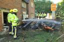 Firefighters at the scene where a McLaren 570s crashed into a telegraph pole and house and burst into flames. Picture by Trevor Porter