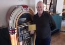 Vyv Scott with his award at The Lamb Inn's jukebox which inspired the birth of a national radio station.