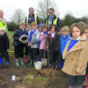 St George’s Primary pupils with Charlie, Flo and Vivien with the oak sapling they planted at the new Jubilee Wood at Littlemarsh