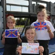 The Mead Primary School pupil Emily with her Go Britain Go flag and school mates Isabelle and Katie with Union flags made to welcome the Tour of Britain. Picture by Trevor Porter