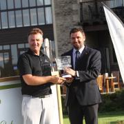 Cumberwell Park director of golf John Jacobs presents the trophy to Sion Bebb (right)