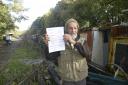 Canal boater George Ward with the legal notice from the Canal & River Trust's to remove' his narrowboat the March Hare from the Kennet & Avon Canal. Photo:  Trevor Porter 69371-1
