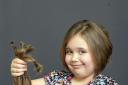 Phoebe Harris with the long locks she is donating to the Little Princess Trust. Photo: Trevor Porter 69664-3