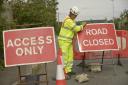 Simon Walmsley,  of  Chevron Traffic Management, installs the road closure and access only signs  on the first day of the B3105 road closure.