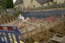 Specialists pour cement during the Bradford on Avon road over rail bridge replacement which is months behind schedule.