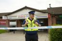 Police preserve the crime scene at the Tesco Express convenience store following the theft from a cash machine.