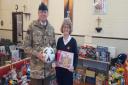 Salvation Army Territorial Envoy Michala Lancefield receives donated toys from the Warminster Garrison Commanding Officer Lieutenant-Colonel Royston Jones.
