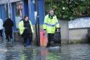 Environment Agency officials check businesses affected by the floods in Bradford on Avo