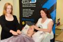 Reiki therapist Dawn Kalsi (right) with assistant Natalie Green (left) working on Sophie Newell, PA to Jordan Daykin, at GripIT fixings, Melksham. Photo www.gphillipsphotography.com  GP810-1
