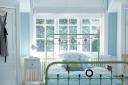 The colour combination of the lime green metal bed, sky blue walls and white floor boards makes the room appear fresh and young. From Living with Light: Decorating the Scandinavian Way by Gail Abbott, published by CICO Books, priced 20