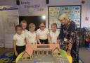 Holbrook Primary School headteacher Vicki Cottrell and pupils take a close look at the specially-made cake identical to the new Coronation Building when it opened last September.
