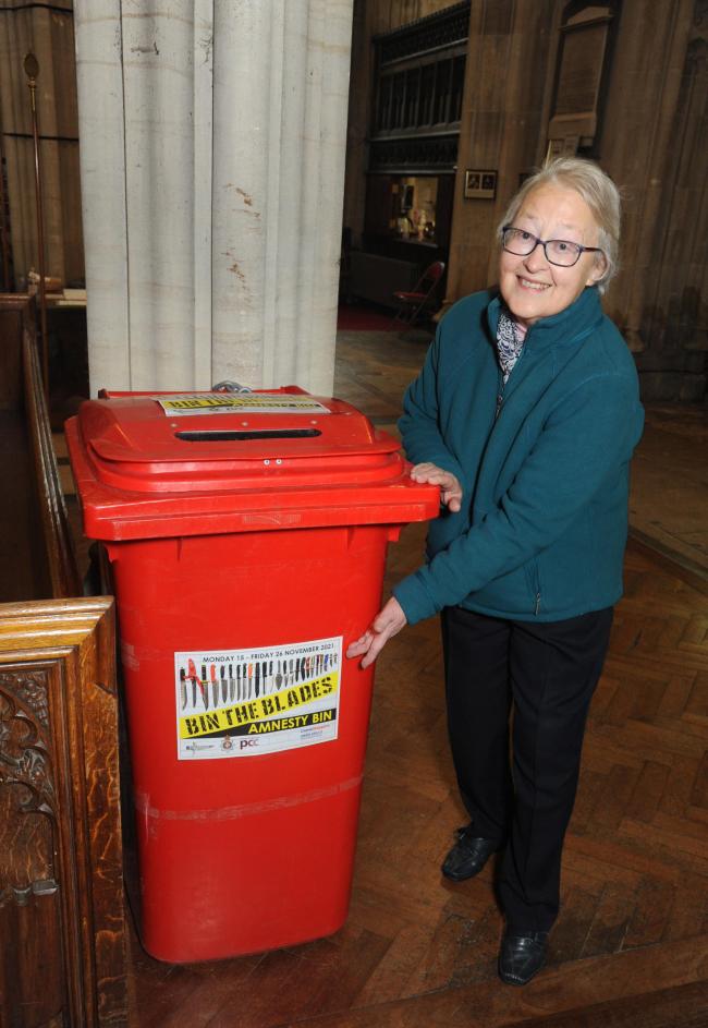 Beryl Morris next to the red bin used to collect unwanted and illegal knives     Trevor Porter