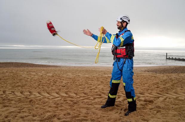 Wiltshire Times: HM Coastguard Coastal Operations Area Commander Tom Wright casts a throwline on Southbourne beach in Dorset (PA)