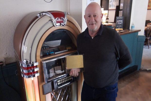 Vyv Scott with his award at The Lamb Inn's jukebox which inspired the birth of a national radio station.