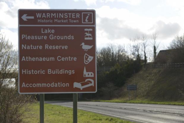 Brown tourism signs on the A350 promote the historic market town of Warminster.