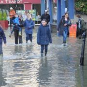 Walkers wade through the flood in the centre of Bradford on Avon.