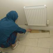 Mehreen Naeem inspects the uneven flooring and files lifting in her downstairs toilet.