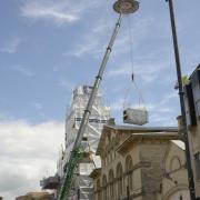 The huge three-tonne air handling unit and air source heat pump is lifted by a 80-tonne crane onto the roof of Trowbridge Town Hall.