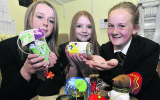 Clarendon Academy’s  Annabel Holland, Erin Stoke and Amy Curtis with some of the decorated jam jars used to collect money for charity